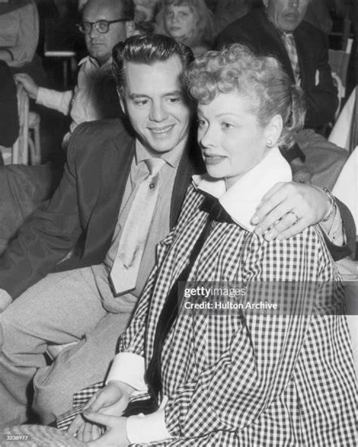Desi Arnaz embraces his pregnant wife,Lucille Ball while watching a televised football game at the Racquet Club in Palm Springs, California in 1953. | Source: Getty Images