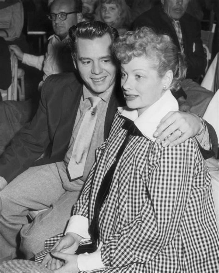 Desi Arnaz embraces his wife, Lucille Ball while watching a televised football game at the Racquet Club in Palm Springs, California, circa 1953 | Photo: Getty Images