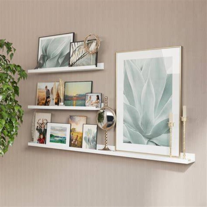 Shelf and wall frames inside Jennifer Aniston and Justin Theroux's LA home. | Photo: YouTube/Architectural Digest